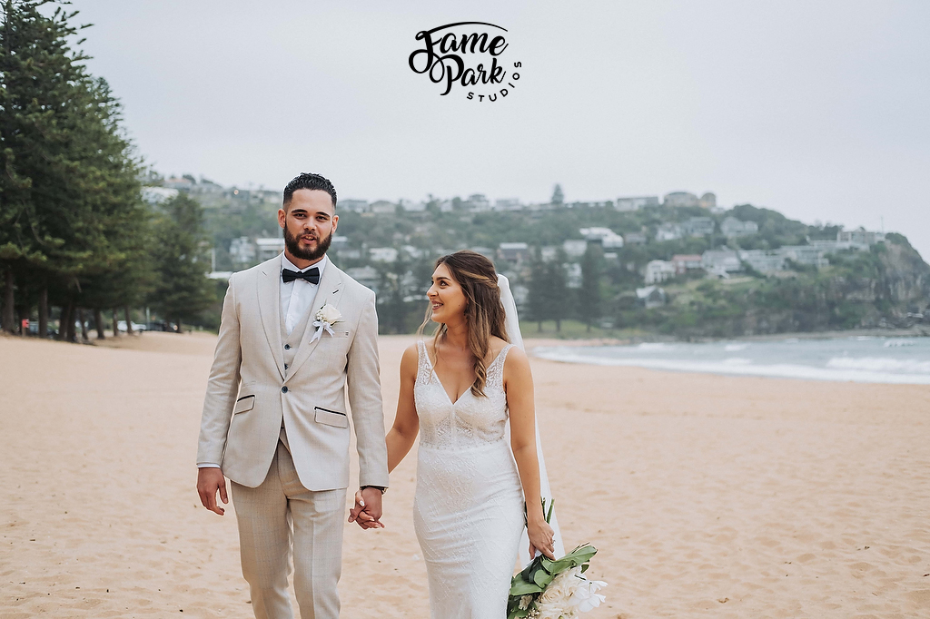 The bride and groom is walking on a beach after their wedding ceremony