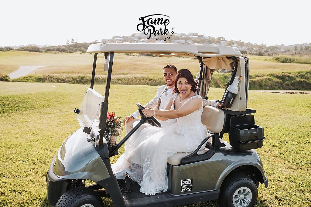 The bride and groom are driving the cart at Palm Beach Golf Club after their wedding