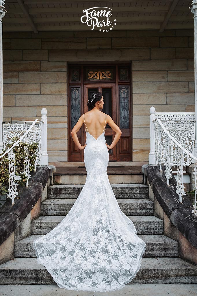 The beautiful bride is wearing her modern boho lace wedding dress with long train
