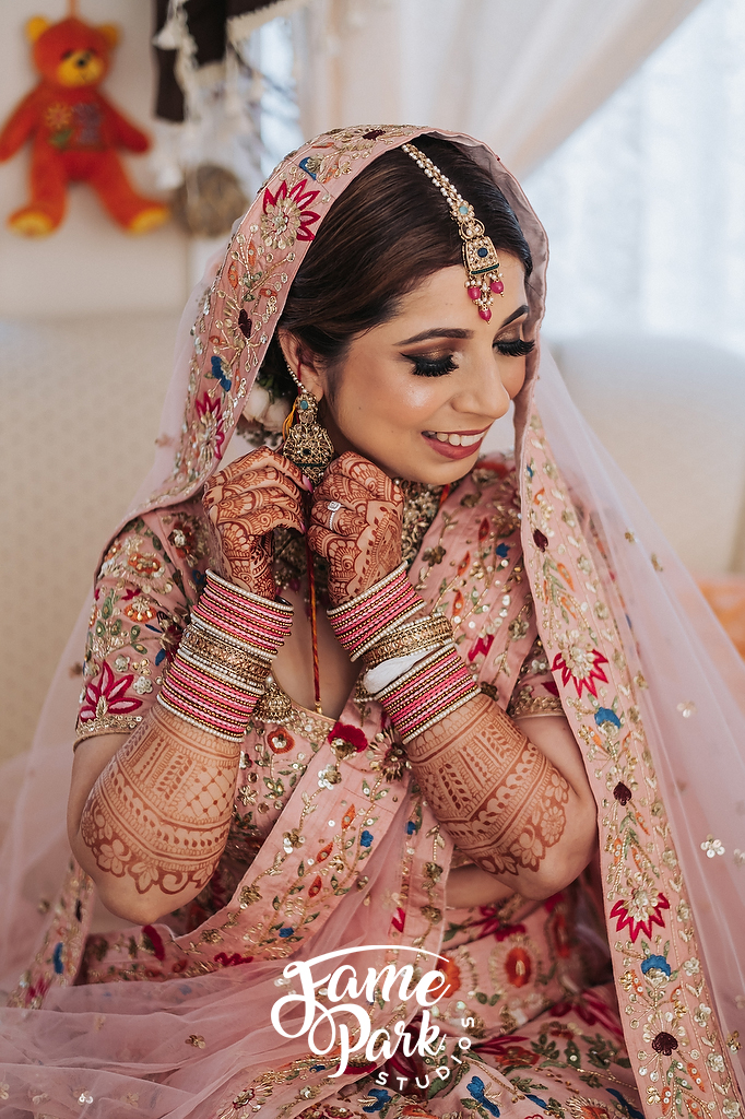 A Indian bride is in her traditional Indian Saree and touching her earrings