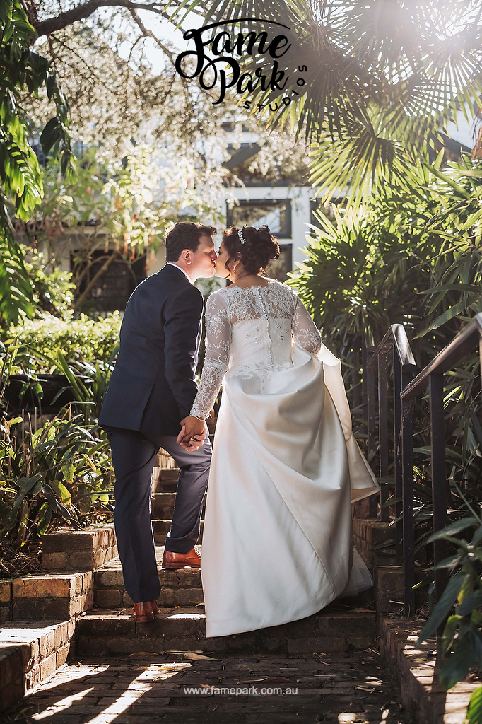 The bride and groom kissing in the beautiful hunter valley garden during the sunset hours.