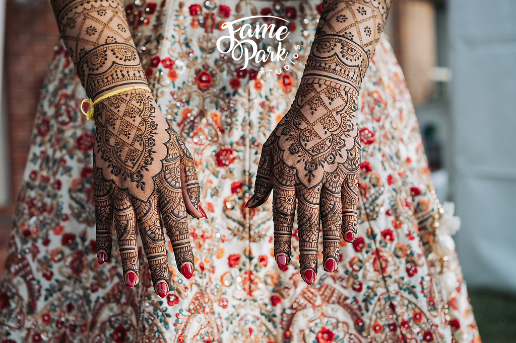 The bride's hands are beautifully mehndi-adorned with henna