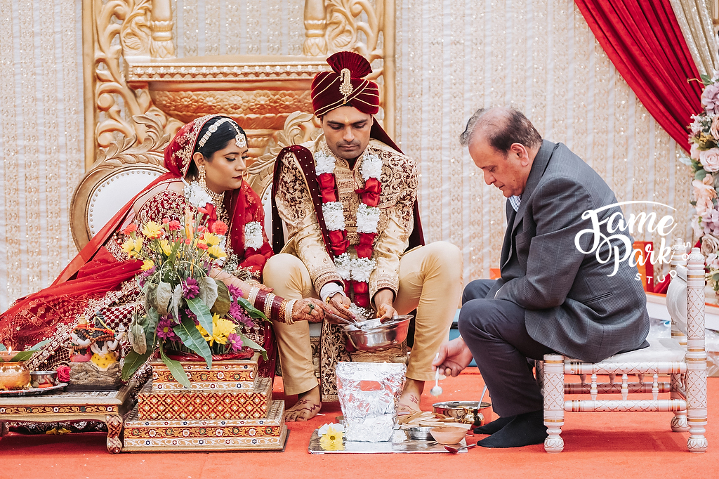The bride and groom is doing one of key rituals of their traditional Indian wedding ceremony.