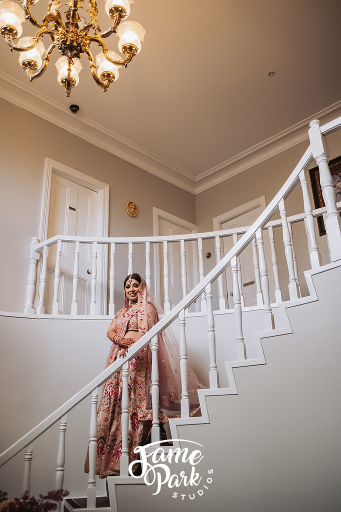 A beautiful bride wearing her Indian saree and standing on the stairs