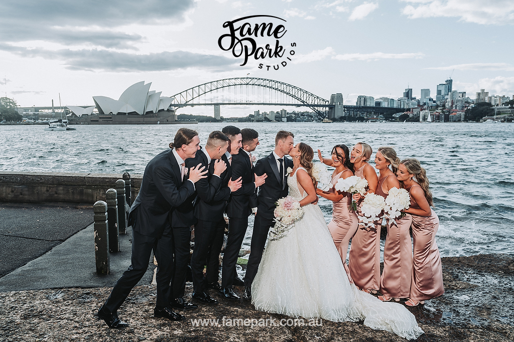 A fun and candid photo of the bridal party with a dual view of Sydney Harbour Bridge and Sydney Opera House