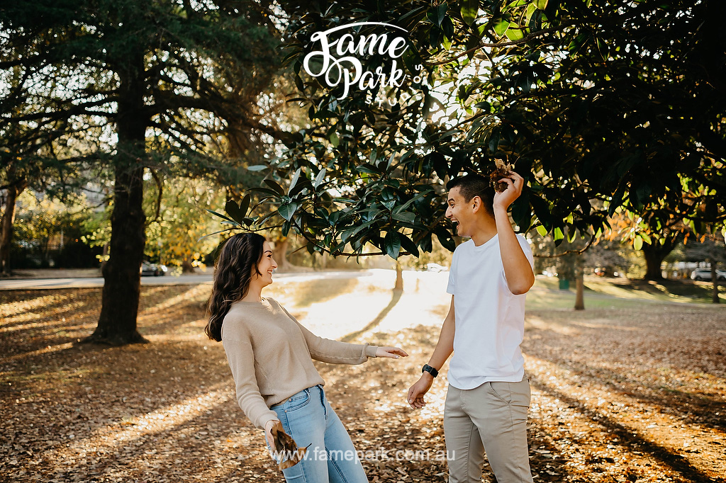 Young couple throwing leave toward each other in a park