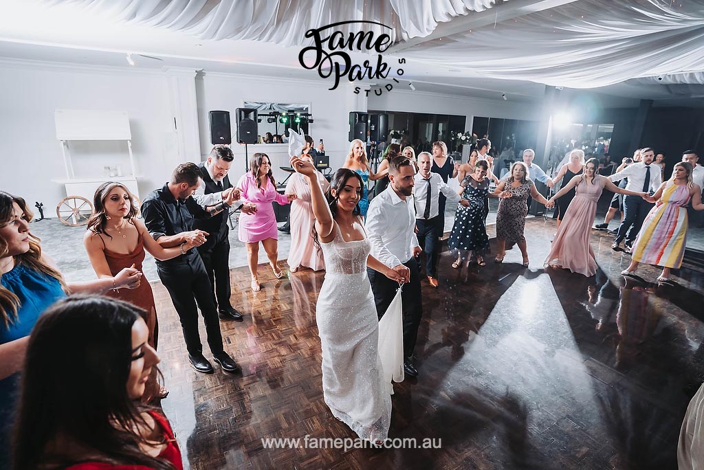 An exuberant scene of a wedding reception where all guests are immersed in the rhythm of the music, their bodies swaying and feet tapping, creating a vibrant and unforgettable atmosphere of celebration.