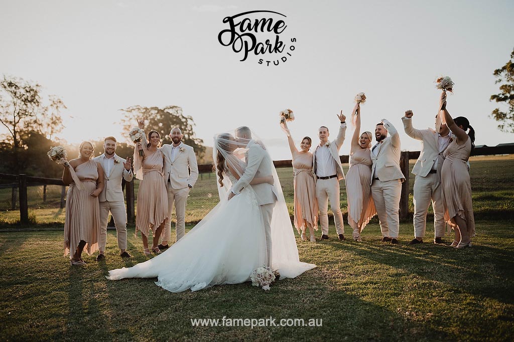 A group of bridesmaids and groomsmen in a field at sunset during a Sydney wedding reception in western Sydney.