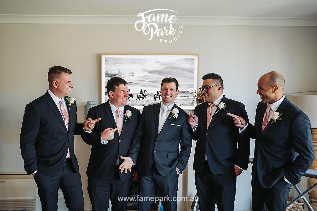 A group of groomsmen in suits and ties, getting ready for the upcoming wedding ceremony.
