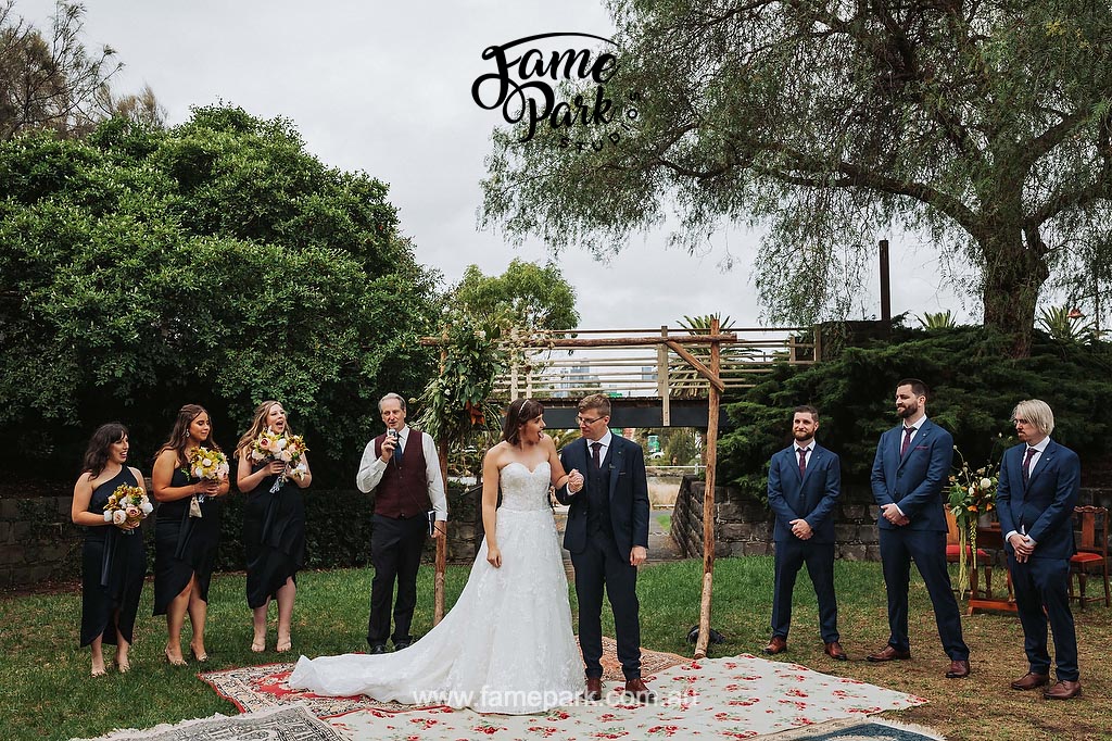 A unity-filled wedding party standing in front of a rug.