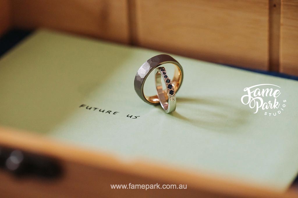A wedding ring rests on a paper invitation.