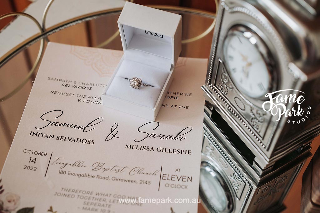 Wedding invitation design ideas are showcased as an elegant invitation sits beside a clock on a table, awaiting guests.